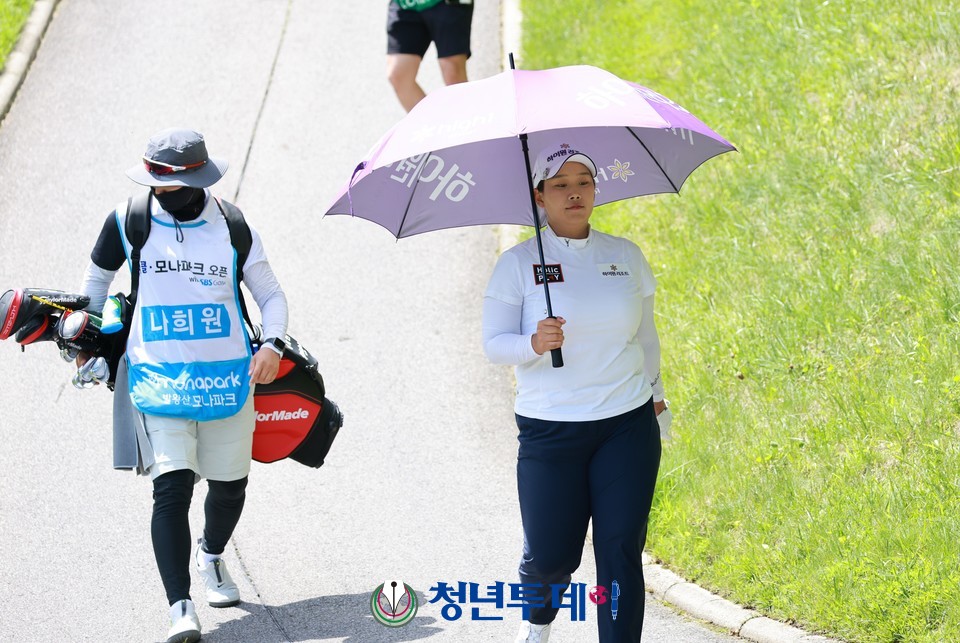 나희원이 대회 이틀째인 2일 11번 홀 에서 티샷을 하고 우산을 쓰고 이동하고있다.2022.07.02