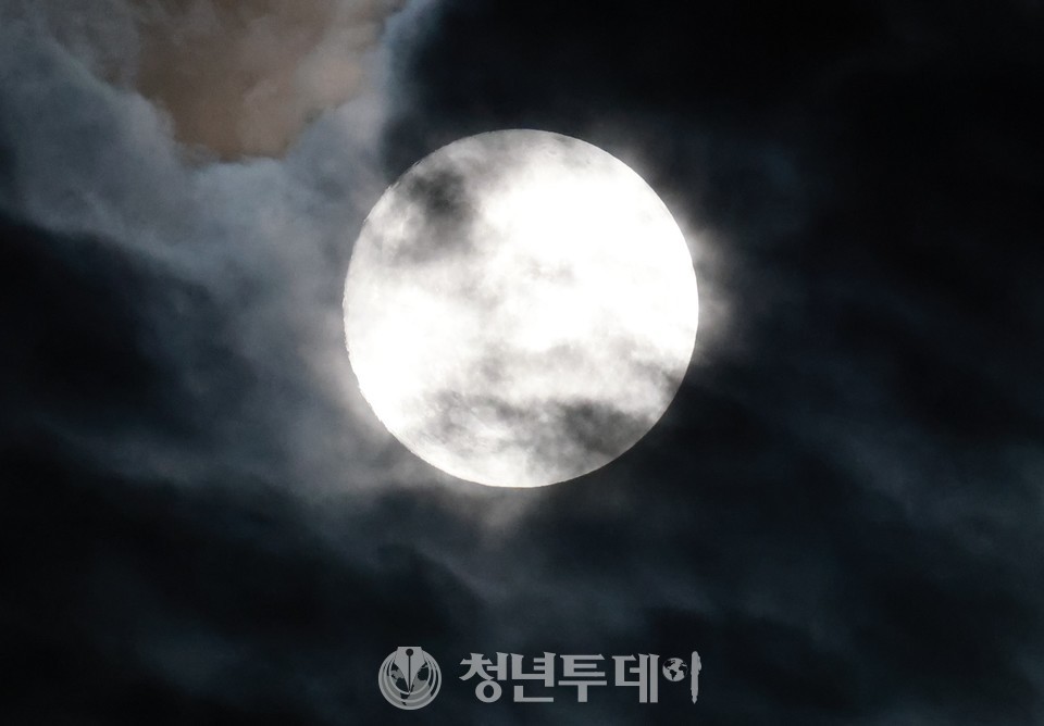 민족 최대 명절인 추서을 하루 앞둔9일 저녁 서울 용산에서 바라본 보름달이 구름에 가려 빚을 밝힌다.2022.09.09