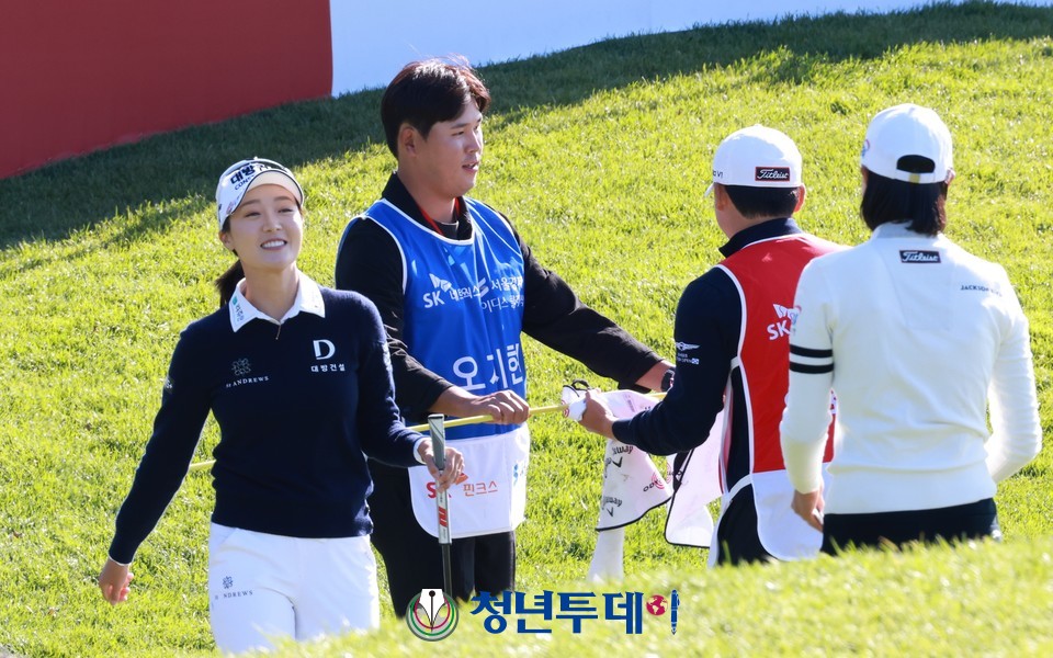 깜짝 캐디로 변신한 김시우가 예비신부인 오지현이 18번홀 버디퍼트를 성공시키자 들고있던 깃대를 동반 캐디에게 건네고 있다.2022.10.27.