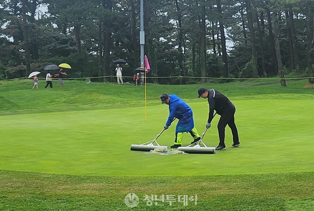 1962년 설립되며 제주도 1호 골프장으로 기록되어 역사와 전통을 자랑하고, 최근 대대적인 리뉴얼을 통해 새롭게 태어난 더시에나 컨트리클럽(구 제주 컨트리클럽) 9번 홀 그린에 빗물이 고여 대회 관계자들이 고인물을 제거하고 있다.2023.07.16